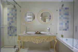 a bathroom with two sinks and a tub and mirrors at Dar Corniche La Marsa (Adults Only) in La Marsa
