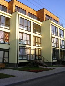 a large building with stairs in front of it at Amber Apartments in Palanga