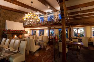 ein Restaurant mit Tischen und Stühlen und einem Kronleuchter in der Unterkunft l'Arrivée Hotel & Spa in Dortmund