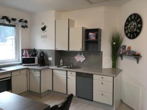 a kitchen with a sink and a clock on the wall at Ferienwohnung Wittenburg in Hermagor