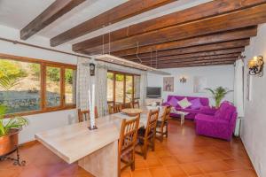 a living room with a dining table and a purple couch at Villa El Olivo in Pollença