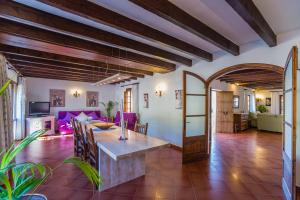 a dining room and living room with purple furniture at Villa El Olivo in Pollença