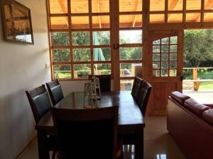 ein Esszimmer mit einem Holztisch und Stühlen in der Unterkunft Casa de Campo Catapilco in Catapilco