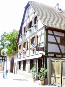 a building with flags on the side of it at Gites Petermann in Marckolsheim