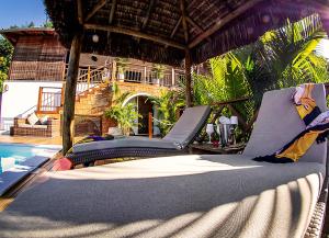 a patio with a bed and a swimming pool at Casa Celestino Residence in Morro de São Paulo