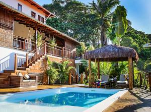 a swimming pool in front of a house at Casa Celestino Residence in Morro de São Paulo