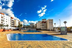 una piscina vacía frente a algunos edificios en Apartamento Palmeras Del Sur, en Adeje