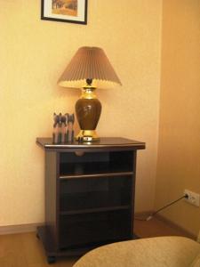 a table with a lamp on top of it at Amber Apartments in Palanga