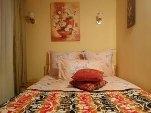 1 cama con 2 almohadas y una pintura en la pared en agropensiunea CASA NICA, en Mărgineni