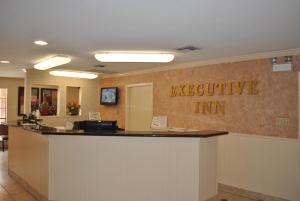 un vestíbulo de oficina con un mostrador de recepción con la posada de texto excelente en Executive Inn Brookshire, en Brookshire