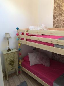 ア・コルーニャにあるÁtico de diseño con terraza.のベッドルーム1室(紫色のマットレスを使用した二段ベッド1組付)