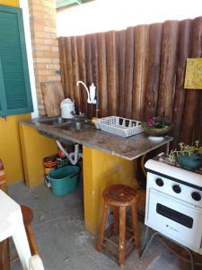 a kitchen with a sink and a stove at Pousada da Tia Lena in Florianópolis