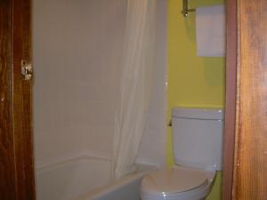 a bathroom with a white toilet and a bath tub at 83 motel in North Platte