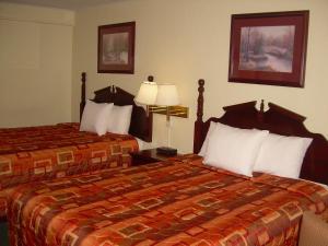 Habitación de hotel con 2 camas y 2 lámparas en 83 motel, en North Platte