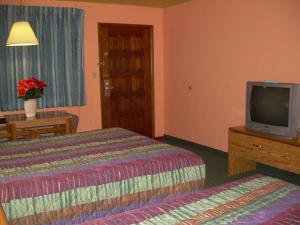 Una habitación de hotel con dos camas y un televisor. en 83 motel, en North Platte