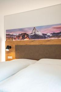 
a hotel room with a bed and a painting on the wall at Residence Patricia in Zermatt
