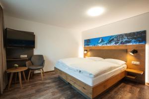 
a hotel room with a bed and a tv at Residence Patricia in Zermatt
