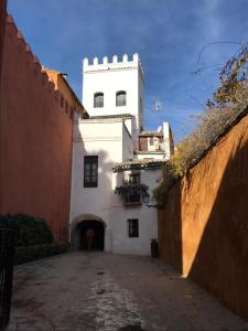 un edificio blanco con una torre encima en Apartamentos Flamenco B&B en Sevilla