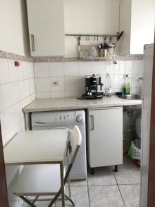 una piccola cucina con elettrodomestici bianchi e una sedia di Sofia Holiday Home a Roma