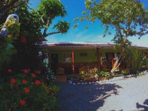 a small green house with flowers in front of it at Hotel Maritza in Puerto Viejo