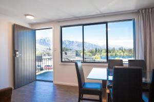 a dining room with a table and a large window at Lomond Lodge Motel & Apartments in Queenstown