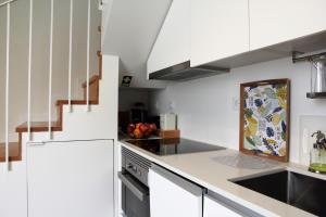 ポルトにあるGreen House / Casa Verdeの白いキャビネットとシンクのあるキッチン