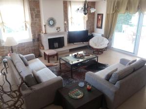 Una sala de estar con dos sofás y un televisor. en Villa Achilleos, en Possidi