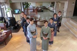 um grupo de pessoas em quimonos de pé em uma sala em Unzen Sky Hotel em Unzen