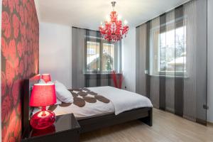 a bedroom with a bed and a red chandelier at Prywatna Rezydencja Marylin Monroe Rabka in Rabka-Zdrój