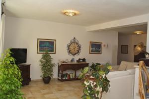 a living room with a couch and a tv at Hotel San Pantaleo in San Pantaleo