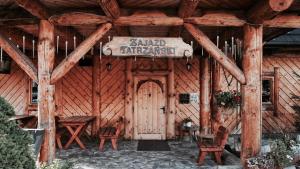 a wooden cabin with a sign on the door at Zajazd Tatrzanski in Kościelisko