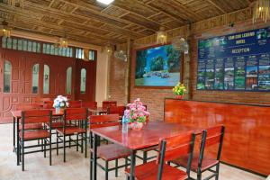 a restaurant with tables and chairs and a menu at Tam Coc Legend Hotel in Ninh Binh