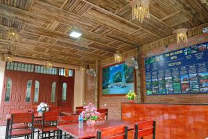 un ristorante con tavoli e sedie in legno e un menù di Tam Coc Legend Hotel a Ninh Binh