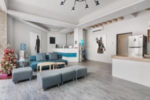 a living room with blue furniture and a kitchen at MUNA Hostel in Hualien City