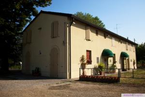 a large white building with a gate in front at Fondo Riso in Faenza