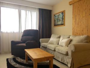 ein Wohnzimmer mit einem Sofa, einem Stuhl und einem Tisch in der Unterkunft YNT 2 Bedroom Apartment with city View in Nagoya