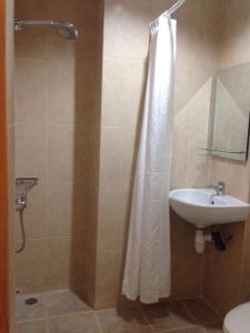 ein Bad mit einem Duschvorhang und einem Waschbecken in der Unterkunft YNT 2 Bedroom Apartment with city View in Nagoya
