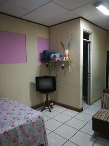 Habitación con cama y TV en la pared. en Belis en Alajuela