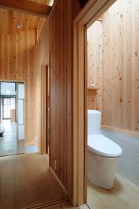 a bathroom with a toilet and wooden walls at Casa OGUMO in Kyoto