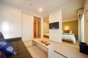 een woonkamer met een bank en een bed bij Hotel MONDONCE Kyoto Gojo in Kyoto
