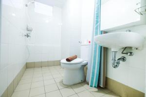 une salle de bain avec toilettes et lavabo dans l'établissement Modern and Comfy 3BR Bassura City Apartment By Travelio, à Jakarta 7 autres photos