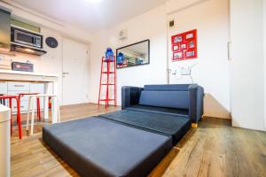 - un grand lit dans une chambre avec une échelle dans l'établissement Modern and Comfy 3BR Bassura City Apartment By Travelio, à Jakarta