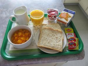 a tray with a sandwich and a cup of coffee and a cup of orange juice at Admirals Motor Lodge in Blenheim