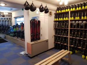 a room with a bunch of skiis on the wall at Chill Madarao in Iiyama