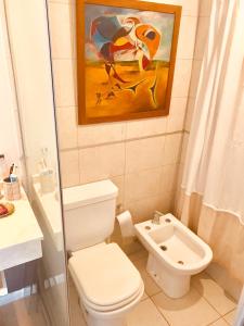 a bathroom with a toilet and a painting on the wall at Departamento Premiun En Zona Centro in Cordoba