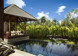 a resort pool with chairs and a gazebo at The Sarojin in Khao Lak