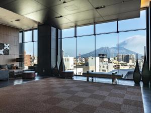 a lobby with a view of a city and mountains at Solaria Nishitetsu Hotel Kagoshima in Kagoshima