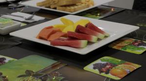 a plate of watermelon and fruit on a table at Puerto Caribe Hostal in Guachaca