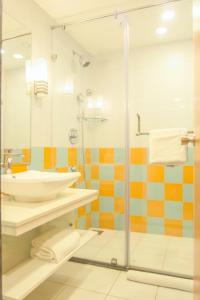 y baño con lavabo y ducha acristalada. en Kalyan Grand - a business hotel en Vandalūr