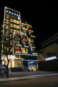 a tall building with a sign on it at night at Aurora Western Village in Ho Chi Minh City